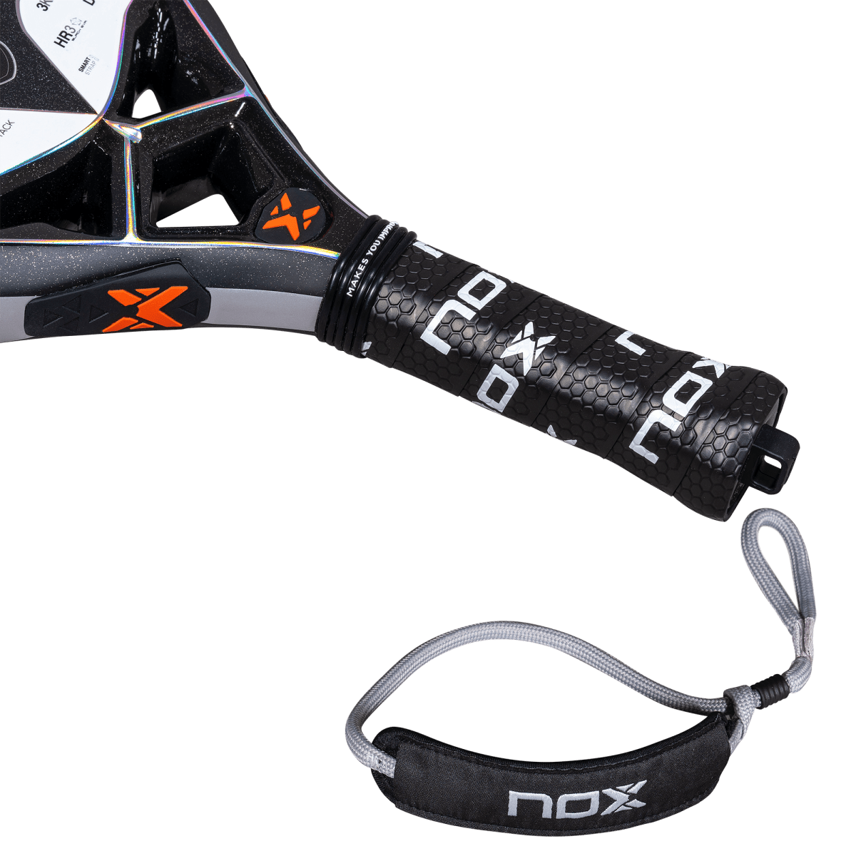 Detalle del puño de la pala de pádel NOX NextGen Pro Attack 3K, con un grip texturizado en color negro y el logotipo de NOX en blanco. Se aprecia el sistema Smart Strap, una correa de seguridad acolchada y ajustable en color negro y gris, diseñada para mayor comodidad y personalización del agarre. También se observan detalles en naranja en el puente de la pala.