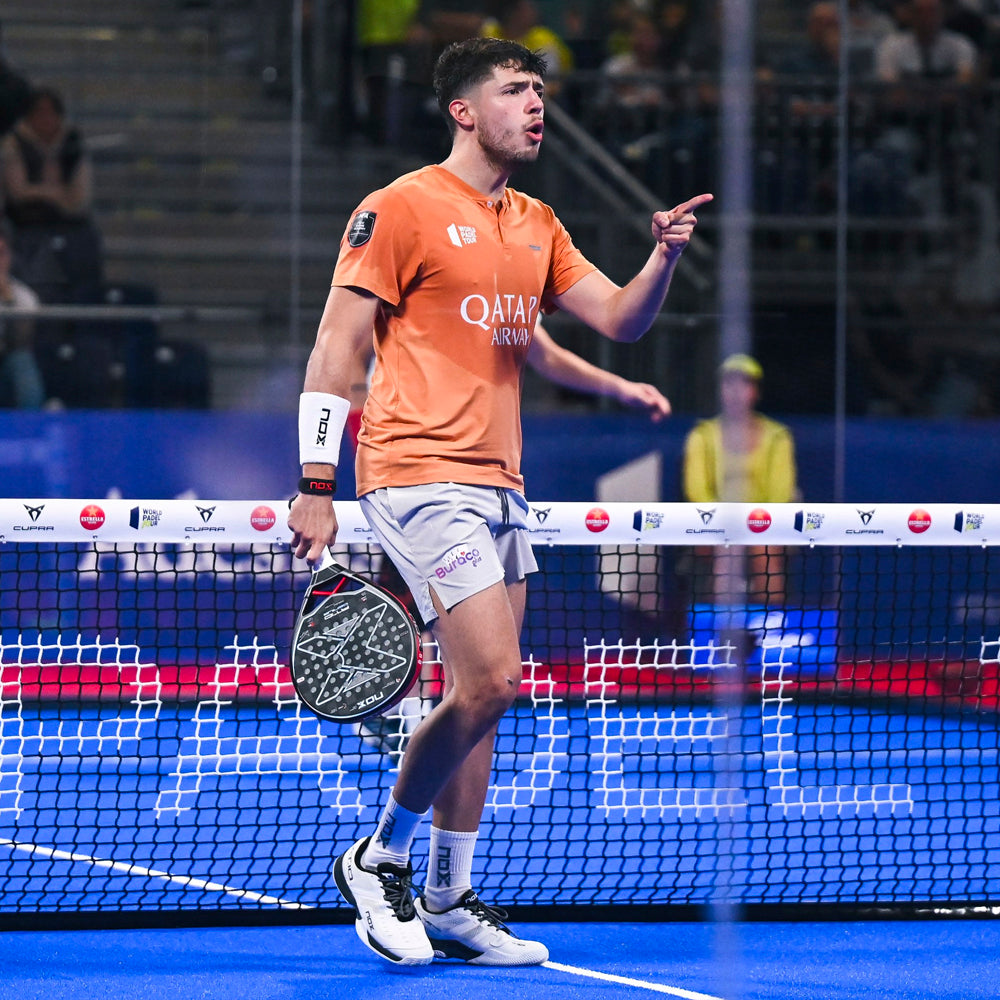 Agustin Tapia competing in orange match kit